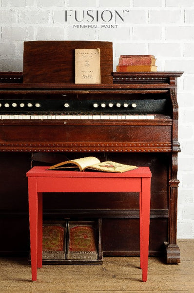 Fusion Mineral Paint | Wooden piano with bench painted in Fort York Red with book on bench.