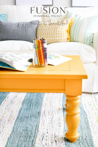 Fusion Mineral Paint | Mustard painted wooden table with pencils and colouring books on top of it in a living room setting.